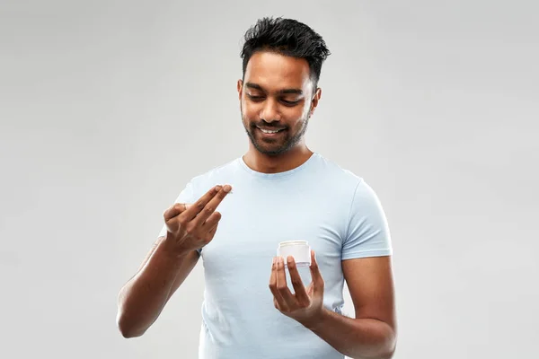 Homem indiano feliz aplicando creme no rosto — Fotografia de Stock