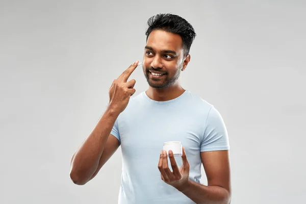 Щасливий індійський чоловік наносить крем на обличчя — стокове фото