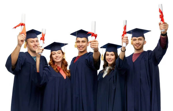 Graduados en morteros con diplomas — Foto de Stock