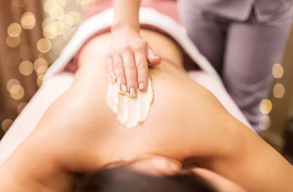 Kobieta o masaż pleców z kremem w spa — Zdjęcie stockowe