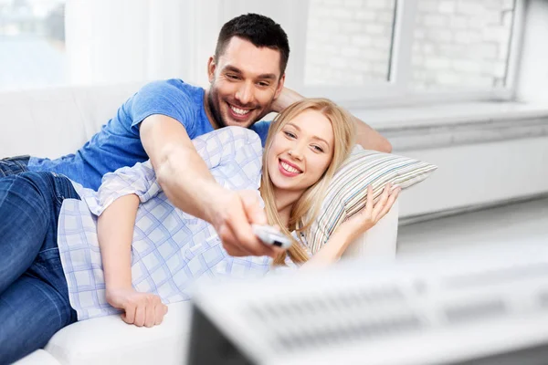 Ευτυχισμένο ζευγάρι χαμογελά βλέποντας τηλεόραση στο σπίτι — Φωτογραφία Αρχείου