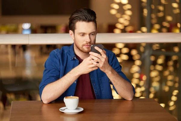 Homme avec café et smartphone au restaurant — Photo