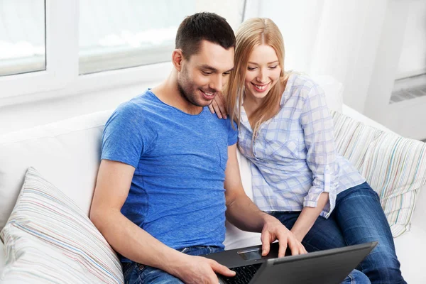 Feliz pareja con ordenador portátil en casa Fotos de stock