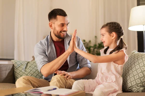 Baba ve kızı birlikte ev ödevi yapıyorlar. — Stok fotoğraf