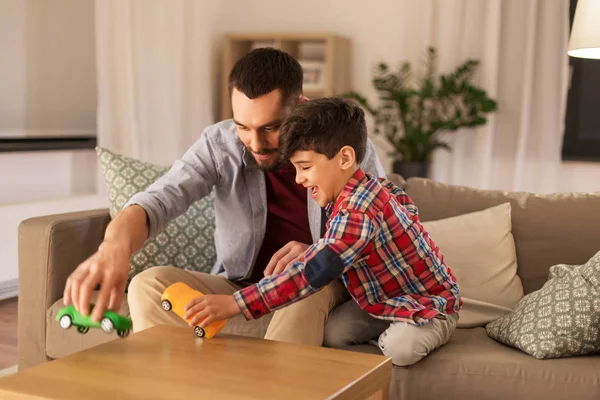 Pai e filho brincando com carros de brinquedo em casa — Fotografia de Stock