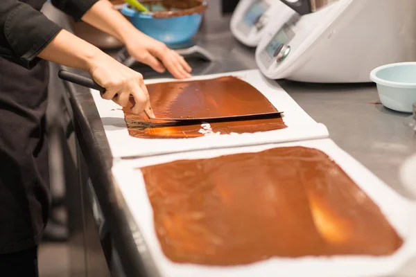 Confitero hace postre de chocolate en la tienda de dulces —  Fotos de Stock