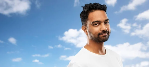Lächelnder junger indischer Mann über blauem Himmel — Stockfoto