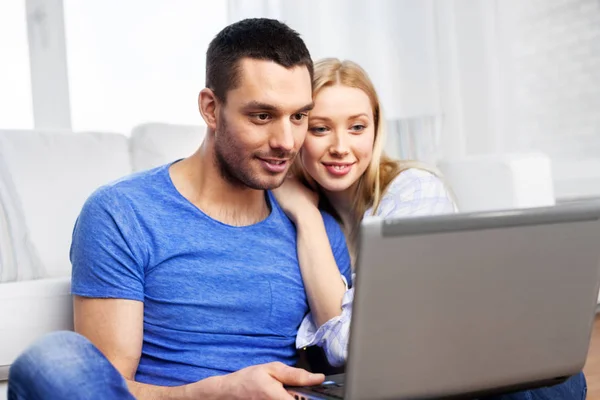 Feliz pareja con ordenador portátil en casa —  Fotos de Stock