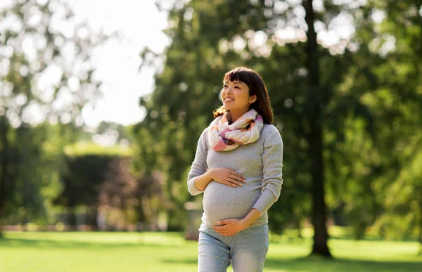 Gelukkig zwangere Aziatische vrouw wandelen in het park — Stockfoto