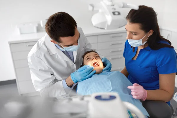 Стоматолог проверяет детские зубы в стоматологической клинике — стоковое фото