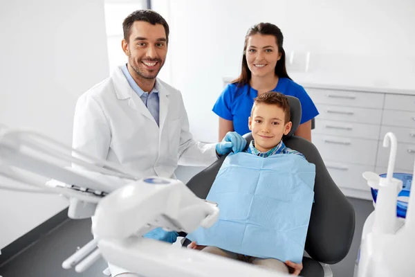 Tandartsen en kid patiënt op tandheelkundige kliniek — Stockfoto