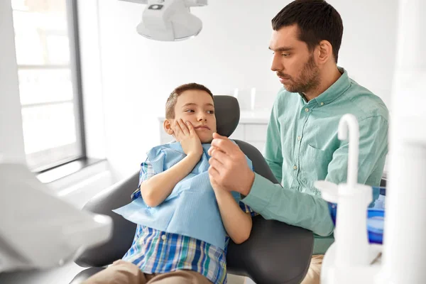 Отец поддерживает сына в стоматологической клинике — стоковое фото