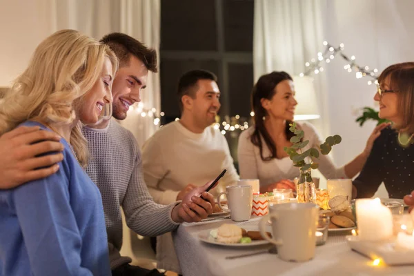 Щаслива пара зі смартфоном на сімейній вечірці чаю — стокове фото