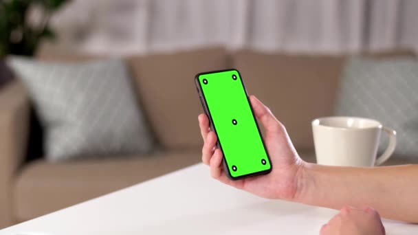 Hand holding smartphone with green screen at home — Stock Video