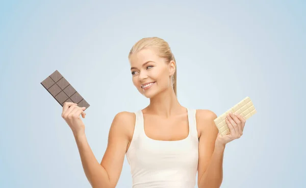 Frau wählt zwischen dunkler und weißer Schokolade — Stockfoto