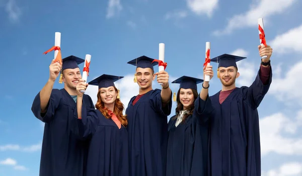 Absolwenci w deski zaprawy z dyplomami — Zdjęcie stockowe