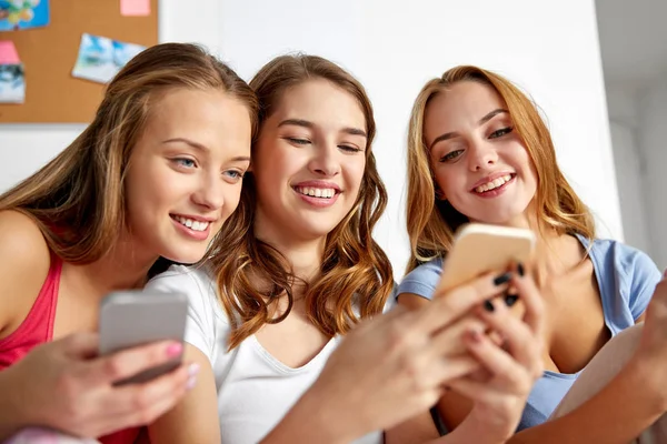 Amigos ou meninas adolescentes com smartphones em casa — Fotografia de Stock