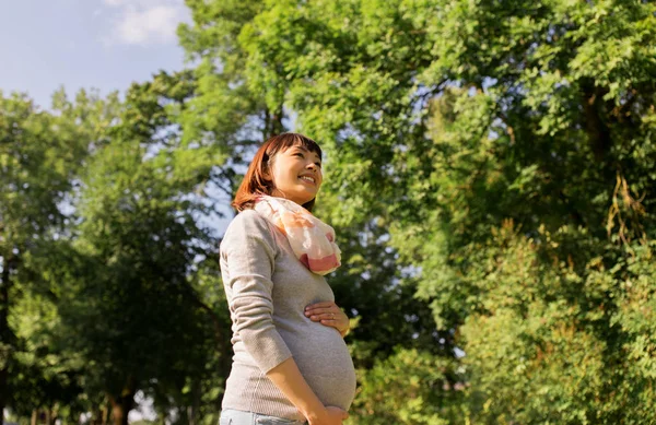 Happy pregnant asian woman at park — Stock Photo, Image