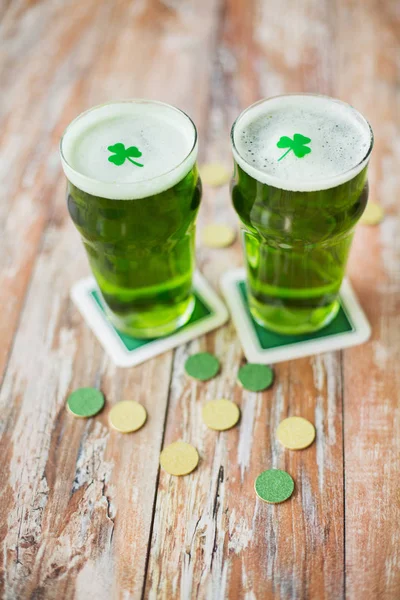 Ποτήρια πράσινο μπύρα με το τριφύλλι και χρυσά νομίσματα — Φωτογραφία Αρχείου