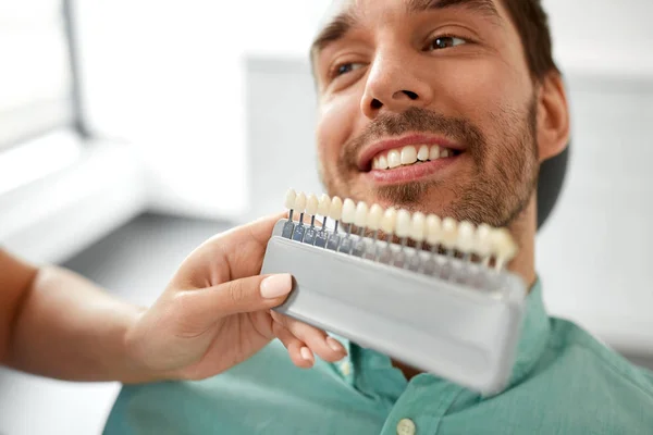 Zubař vybrat barvu zubu pro pacienta na klinice — Stock fotografie