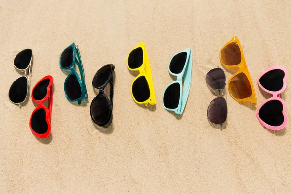 Různé brýle na pláži písek — Stock fotografie