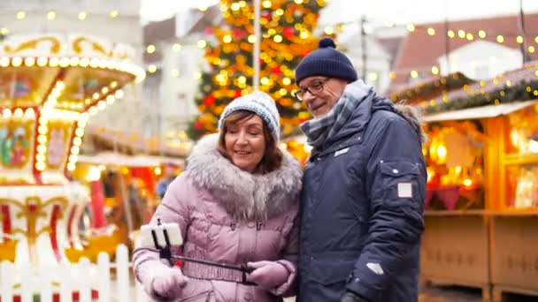 Starší pár s selfie na vánočním trhu — Stock video