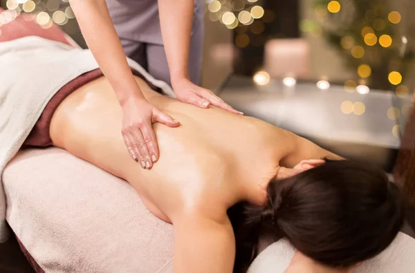 Mulher deitada e tendo massagem nas costas no salão de spa — Fotografia de Stock