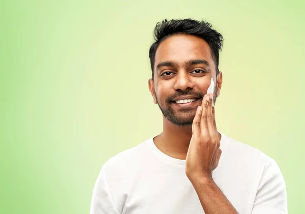 Felice uomo indiano applicando crema per il viso — Foto Stock