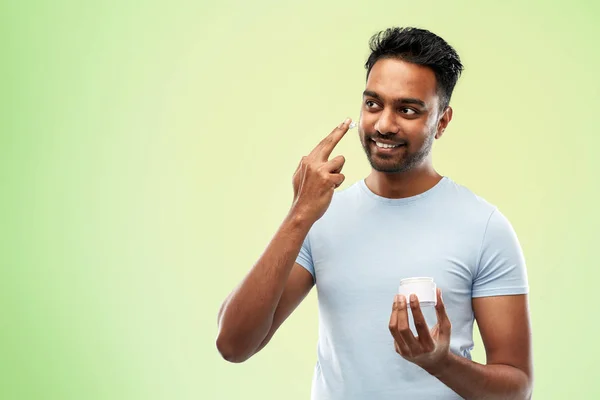 Felice uomo indiano applicando crema per il viso — Foto Stock