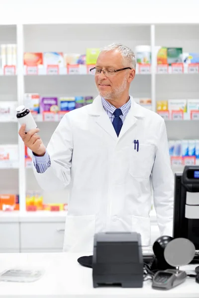 Boticario senior con medicamento en la farmacia — Foto de Stock