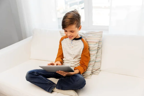 Usměvavý chlapec s počítačem tablet pc doma — Stock fotografie
