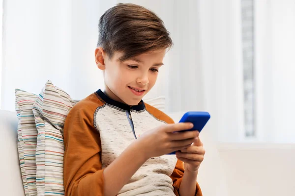 Happy smiling boy with smartphone at home — Stock Photo, Image