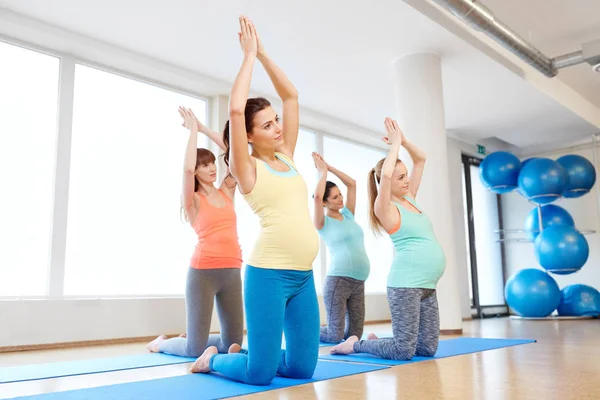 Mujeres embarazadas felices haciendo ejercicio sobre alfombras en el gimnasio — Foto de Stock