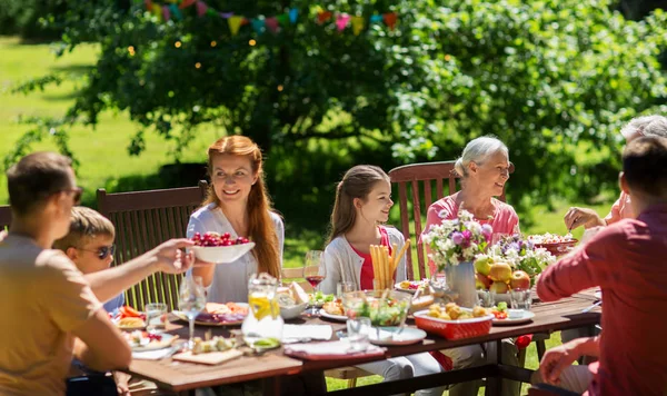 Mutlu bir aile yemek yiyor ya da bahçe partisi veriyor. — Stok fotoğraf