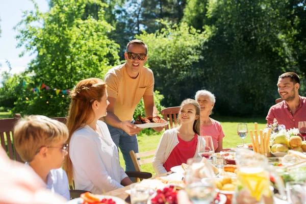 Familie beim Abendessen oder Grillen im Sommergarten — Stockfoto