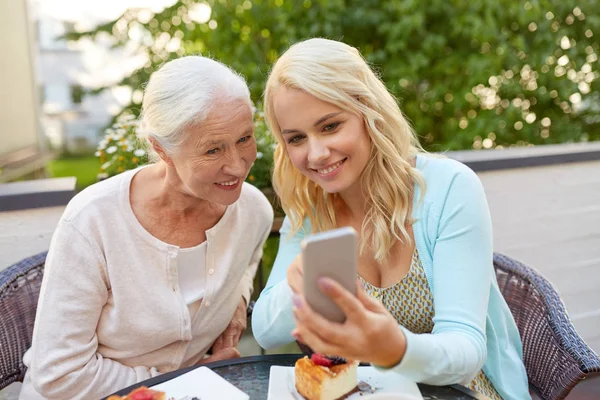 Dotter och senior mor med smartphone på café — Stockfoto