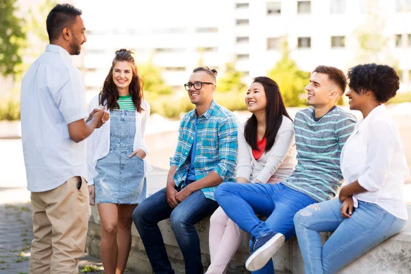 Amigos internacionais felizes falando no parque — Fotografia de Stock