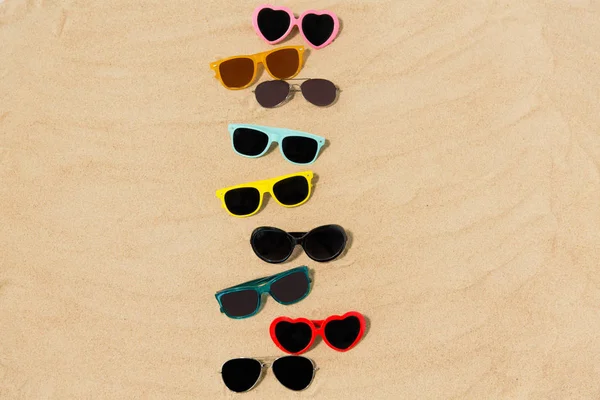 Різні сонцезахисні окуляри на пляжі пісок — стокове фото