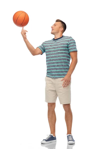 Smiling young man spinning ball on finger — Stock Photo, Image