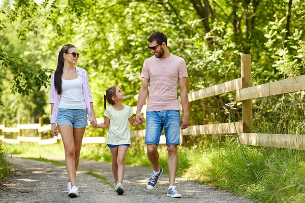 Ευτυχισμένη οικογένεια με τα πόδια στο πάρκο το καλοκαίρι — Φωτογραφία Αρχείου