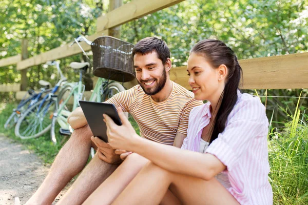 Para z komputera typu tablet i rowery w lato park — Zdjęcie stockowe