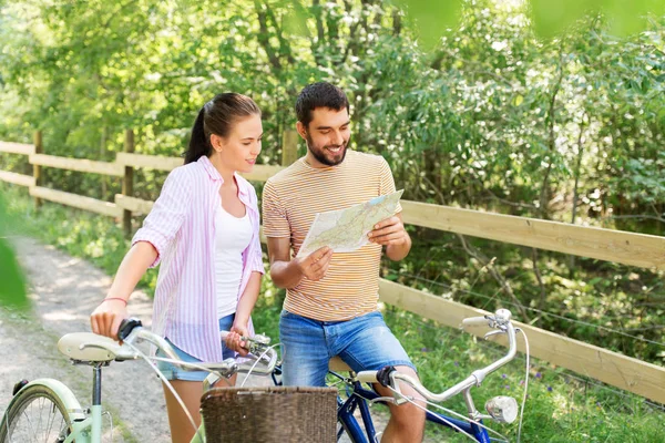 Coppia con mappa e biciclette in campagna in estate — Foto Stock