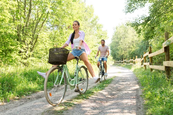 Happy couple with bicycles at summer park — Stock Photo, Image