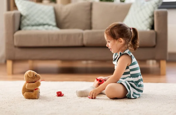 Niña jugando con juego de té de juguete en casa —  Fotos de Stock