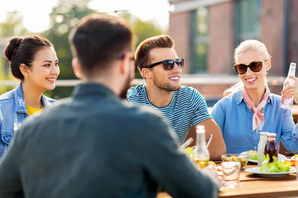 Přátelé mají večeři nebo bbq party na střeše — Stock fotografie