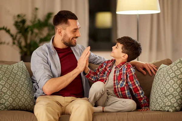 Far och son att göra high five på hemma i kväll — Stockfoto