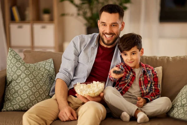 Far och son med popcorn på tv hemma — Stockfoto