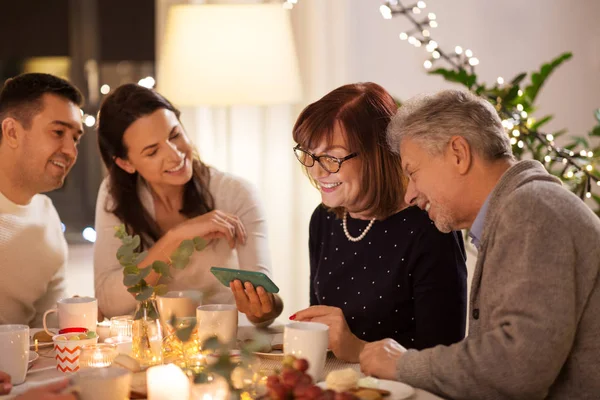 Mutlu aile ile evde çay partisinde smartphone — Stok fotoğraf