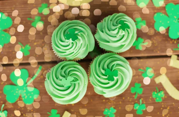 Green cupcakes and shamrock on wooden table — Stock Photo, Image