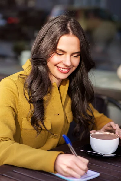 Ευτυχισμένη γυναίκα με φορητό πόσιμο κακάο στο café — Φωτογραφία Αρχείου